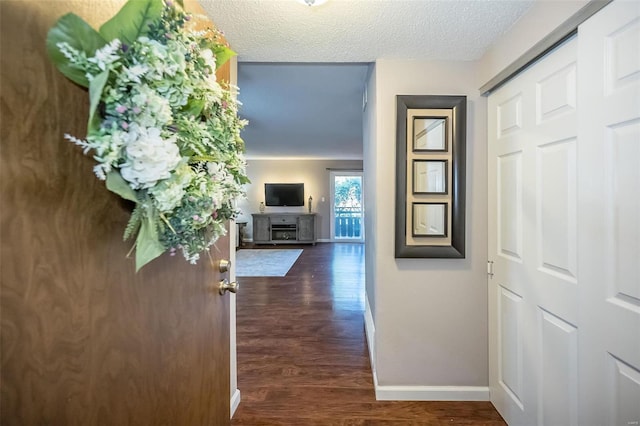 hallway featuring dark hardwood / wood-style flooring and a textured ceiling