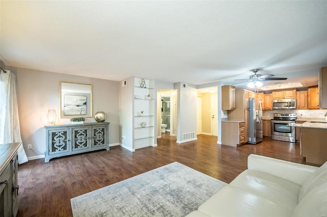 living room featuring dark hardwood / wood-style floors, ceiling fan, and sink