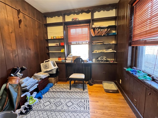 office featuring wood walls, light hardwood / wood-style flooring, and radiator heating unit