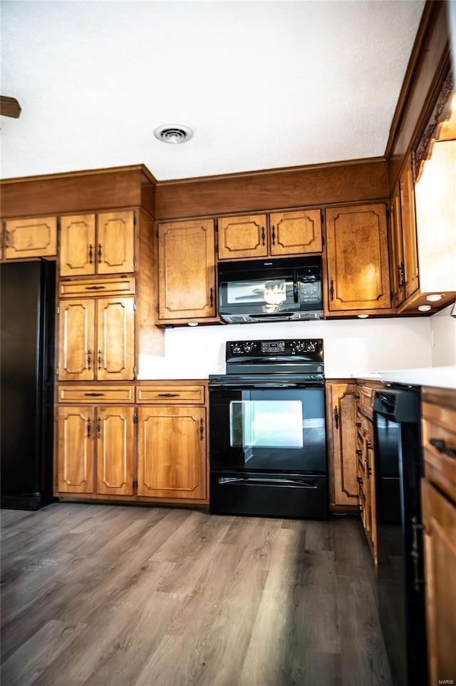 kitchen featuring dark hardwood / wood-style floors and black appliances