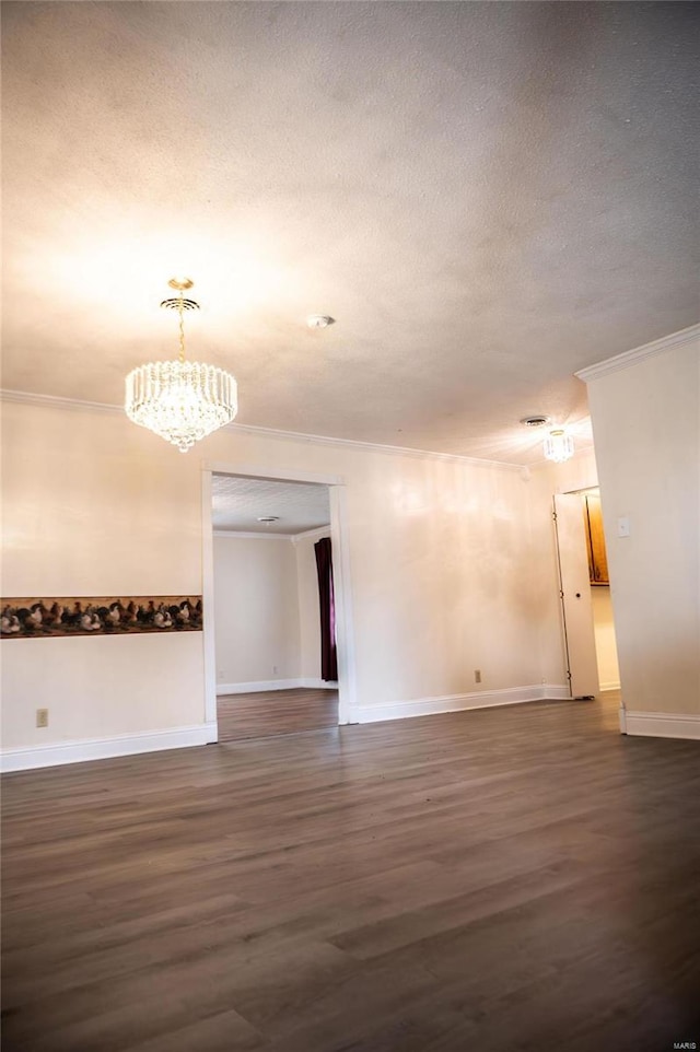 unfurnished room featuring a textured ceiling, crown molding, dark hardwood / wood-style flooring, and a chandelier