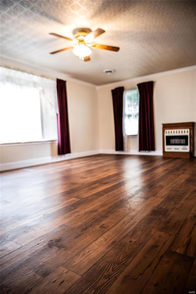 spare room with ceiling fan, ornamental molding, heating unit, a textured ceiling, and dark hardwood / wood-style floors