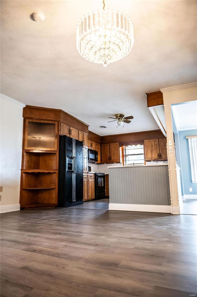 interior space featuring ceiling fan with notable chandelier, dark hardwood / wood-style floors, ornamental molding, and black appliances