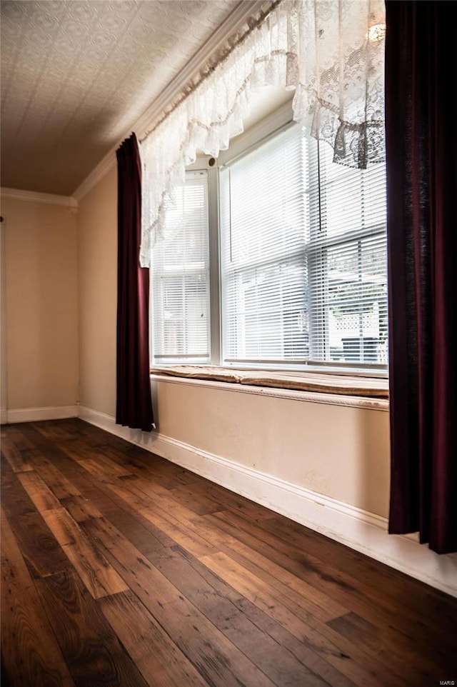 empty room with a textured ceiling, crown molding, and dark hardwood / wood-style flooring