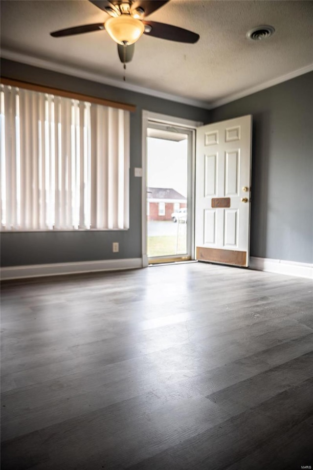 empty room with ceiling fan, crown molding, and a textured ceiling