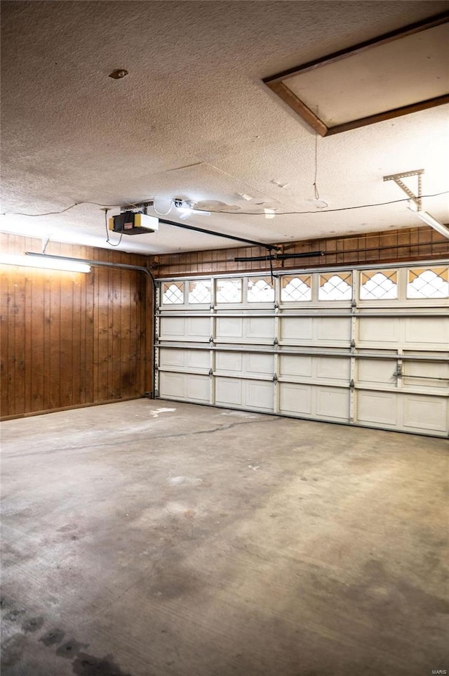 garage with a garage door opener and wood walls