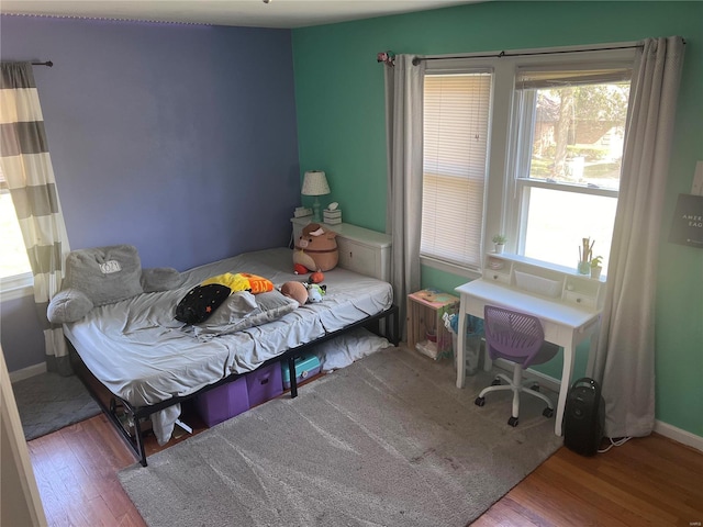 bedroom featuring hardwood / wood-style flooring and multiple windows