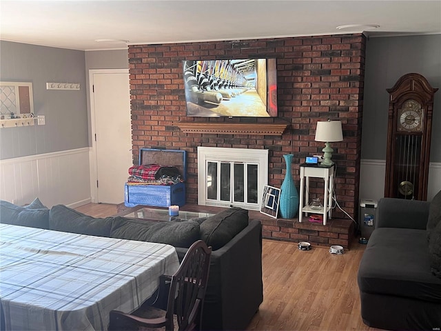 living room with wood-type flooring and a brick fireplace