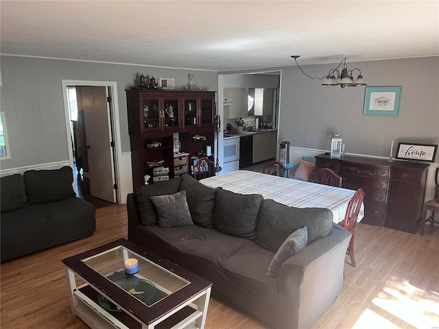 living room with sink, light hardwood / wood-style flooring, and a notable chandelier