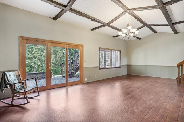 empty room featuring a notable chandelier, hardwood / wood-style floors, and a healthy amount of sunlight