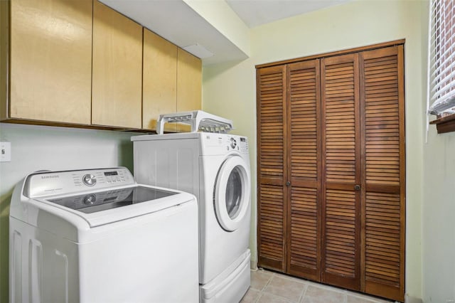 laundry area with separate washer and dryer, cabinets, and light tile patterned floors