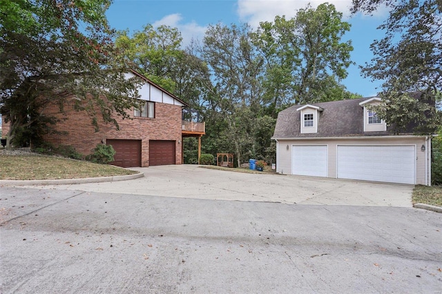 view of side of property featuring a balcony and a garage