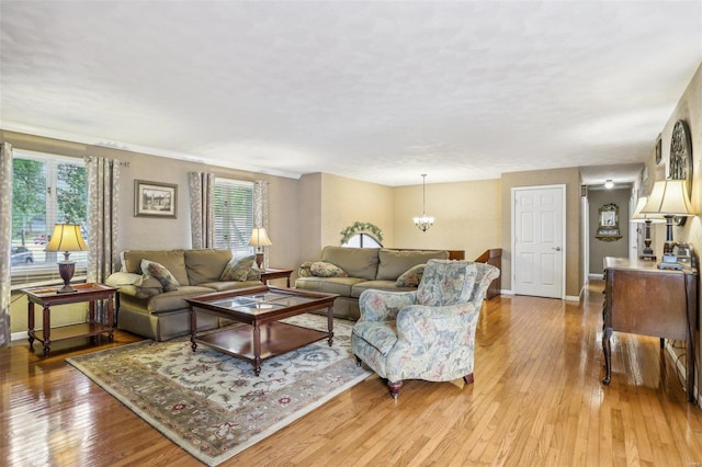 living room with light wood-type flooring and a chandelier