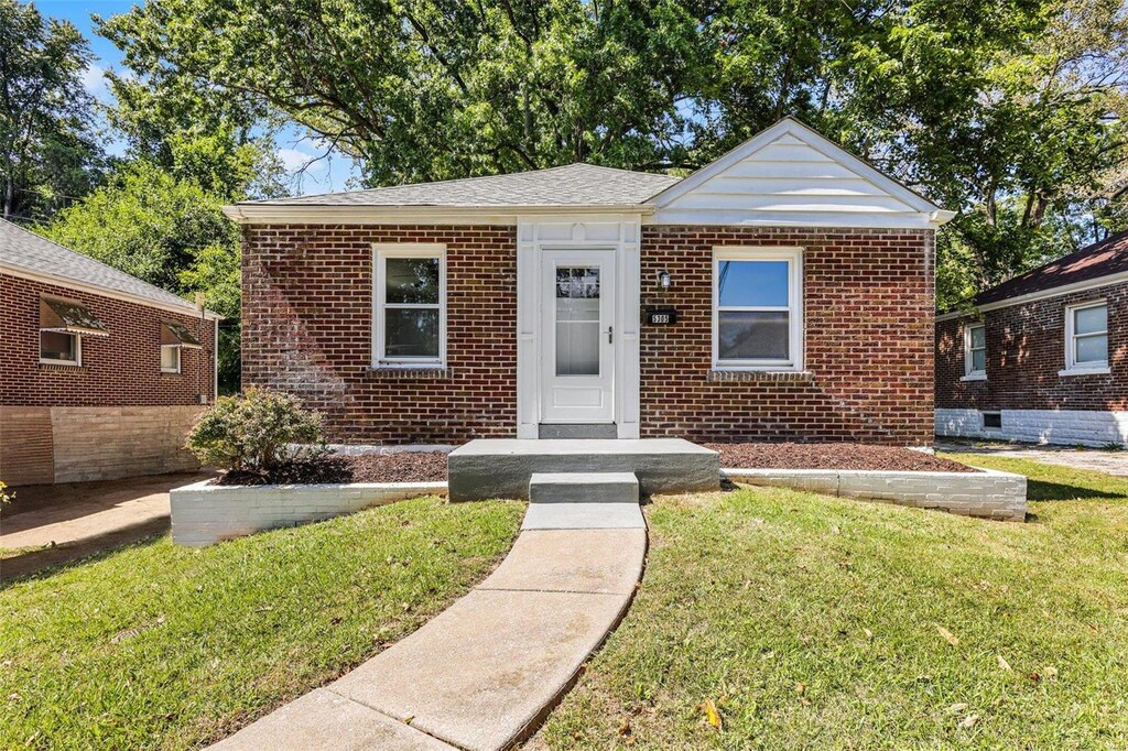 bungalow-style home with a front yard