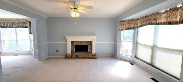 unfurnished living room featuring ceiling fan, ornamental molding, light carpet, and a brick fireplace