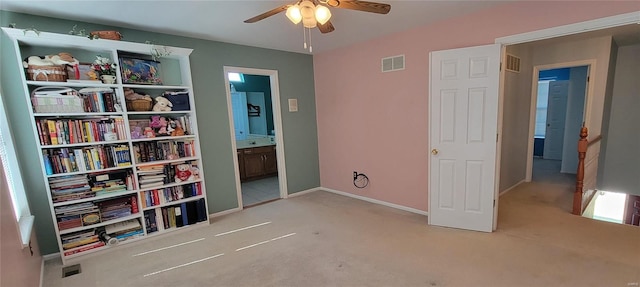 carpeted bedroom with connected bathroom and ceiling fan