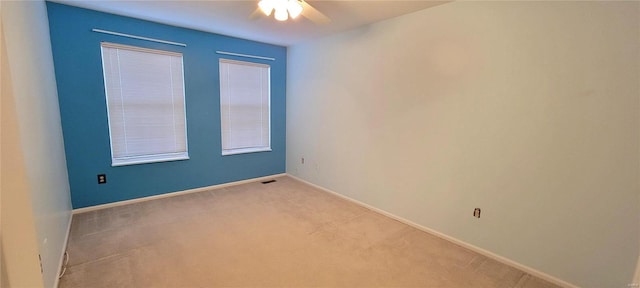 spare room with light colored carpet and ceiling fan