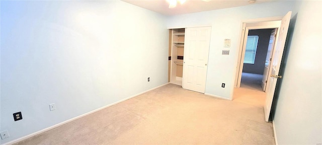 unfurnished bedroom with light carpet, a closet, and ceiling fan