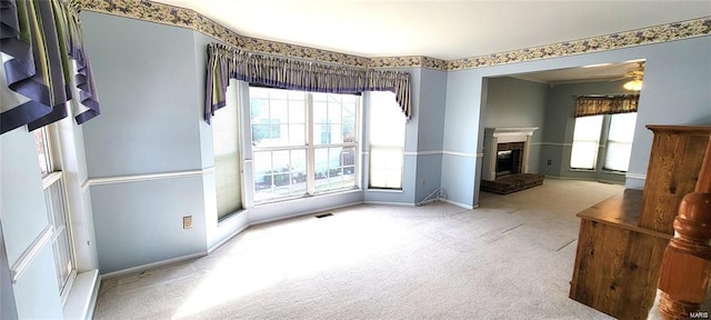 interior space featuring plenty of natural light, light colored carpet, and a fireplace