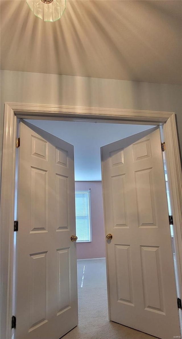 corridor featuring light colored carpet