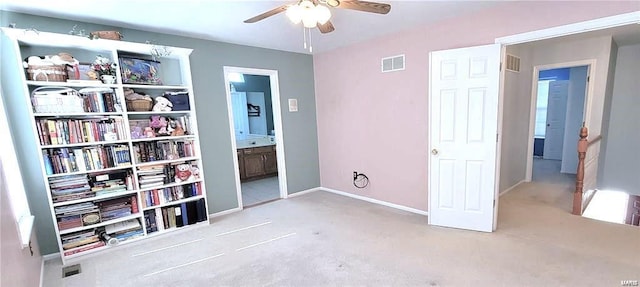 unfurnished bedroom featuring light carpet, ensuite bath, and ceiling fan