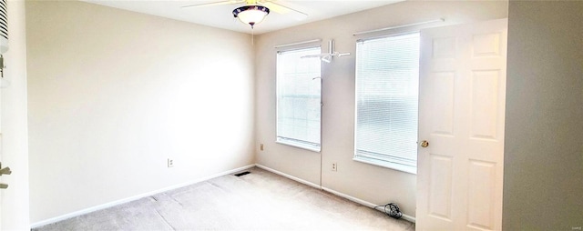 carpeted empty room featuring a wealth of natural light and ceiling fan