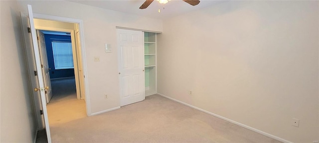 unfurnished bedroom with light colored carpet, a closet, and ceiling fan