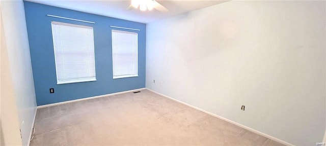 spare room featuring ceiling fan and light carpet