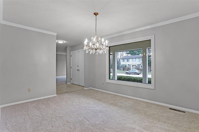 carpeted spare room featuring ornamental molding, a textured ceiling, and a notable chandelier