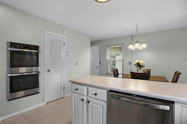 kitchen with an inviting chandelier, hanging light fixtures, light tile patterned flooring, white cabinetry, and stainless steel appliances