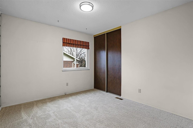 unfurnished bedroom with a closet, carpet floors, and a textured ceiling