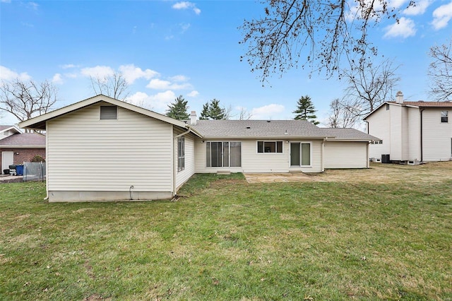 rear view of property featuring a lawn