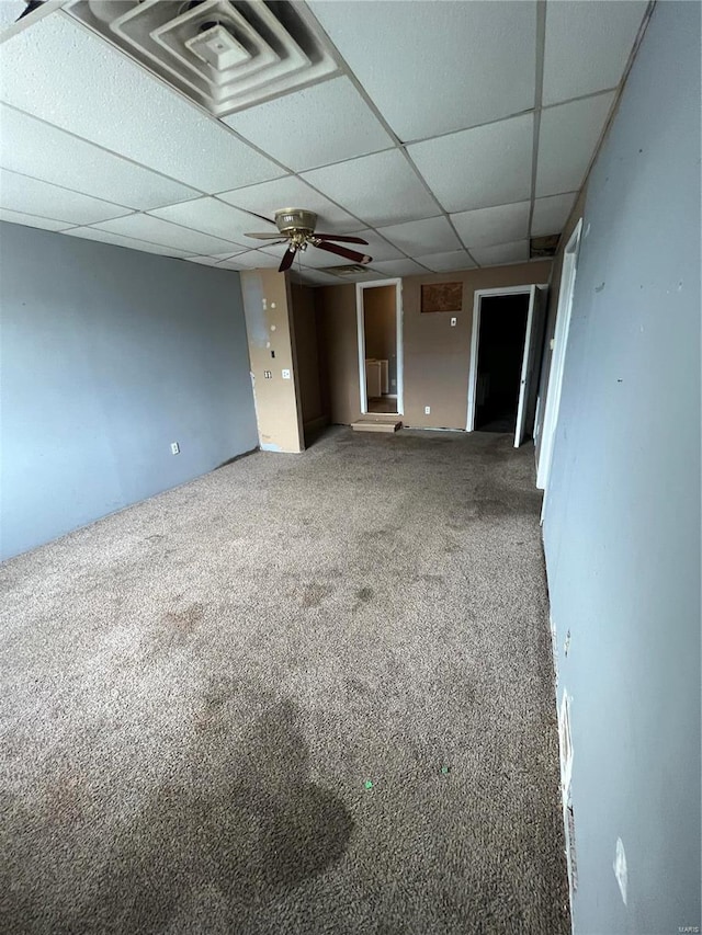 carpeted spare room featuring ceiling fan and a paneled ceiling