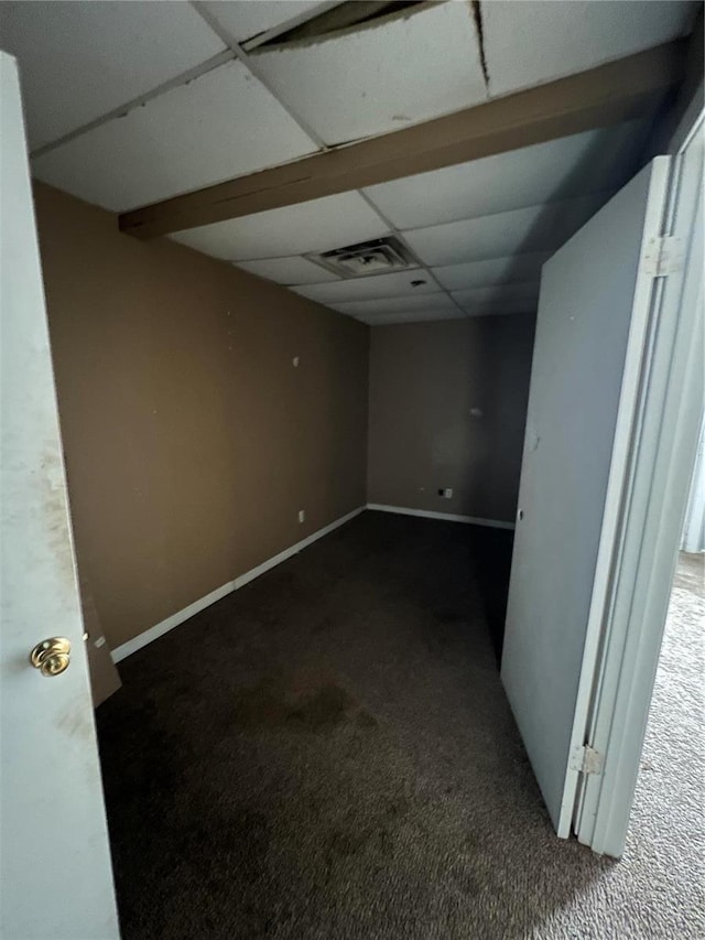 unfurnished room featuring a paneled ceiling and carpet flooring