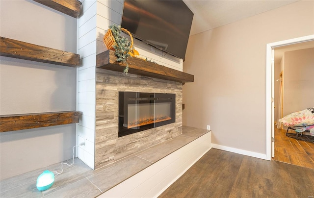 interior details with hardwood / wood-style flooring and a tiled fireplace