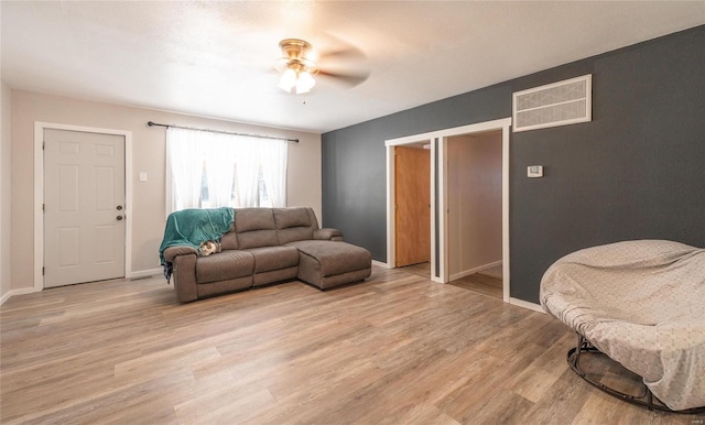 living room with light hardwood / wood-style flooring and ceiling fan