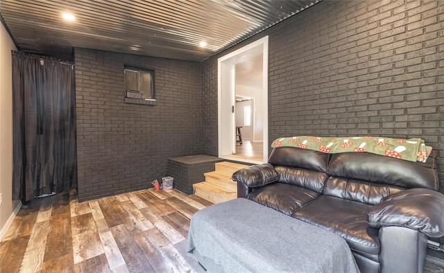 living room featuring brick wall and hardwood / wood-style flooring