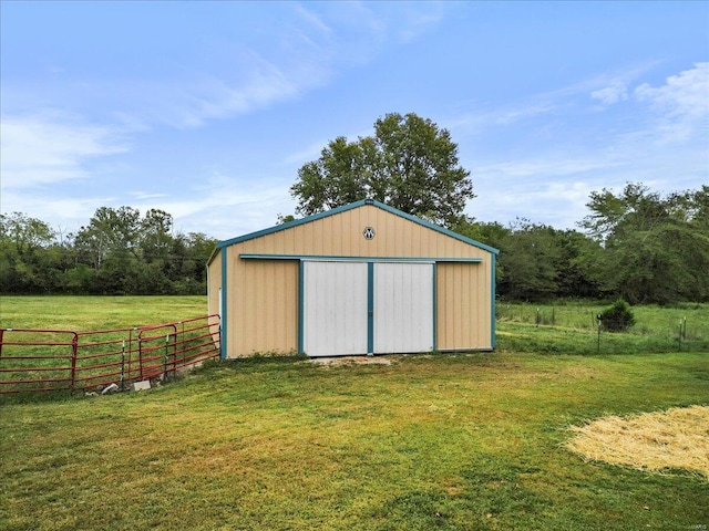 view of outbuilding with a rural view and a yard