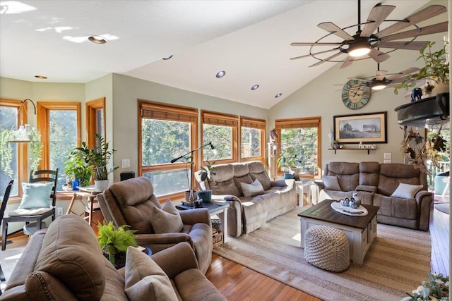 living room featuring ceiling fan, light wood-type flooring, vaulted ceiling, and a wealth of natural light