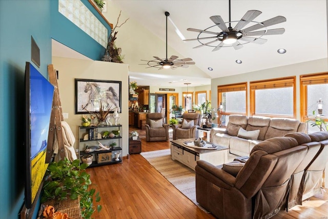 living room featuring light wood-type flooring, ceiling fan, and high vaulted ceiling