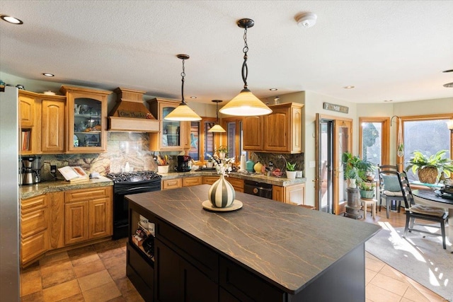 kitchen featuring black appliances, backsplash, custom range hood, and a center island