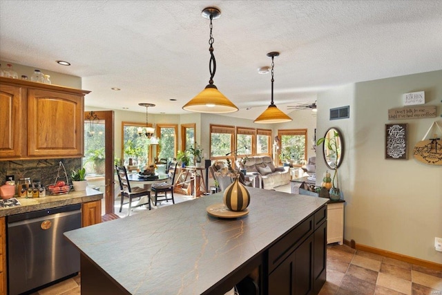 kitchen with a textured ceiling, backsplash, stainless steel dishwasher, and pendant lighting