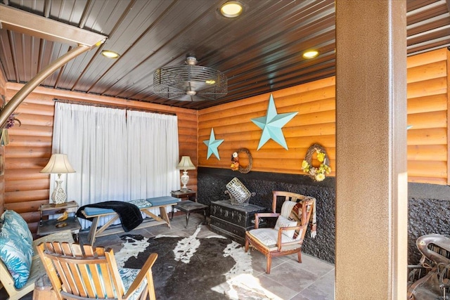 living room featuring wooden ceiling, ceiling fan, and rustic walls