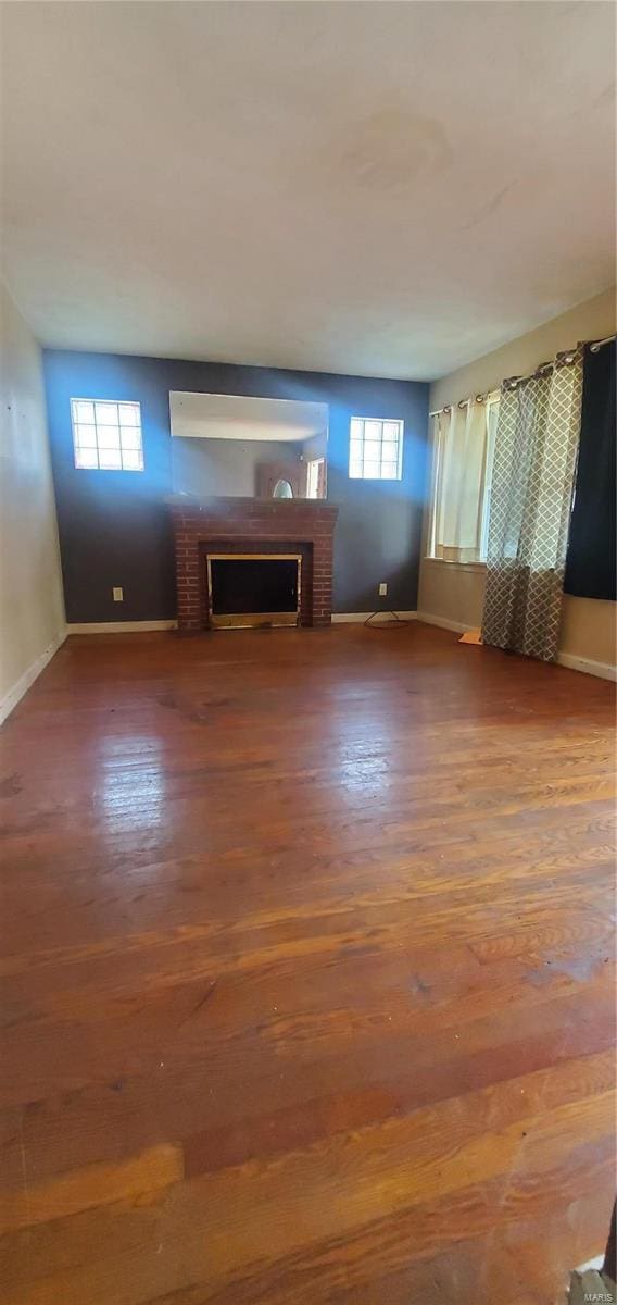 unfurnished living room featuring a fireplace, hardwood / wood-style floors, and a healthy amount of sunlight