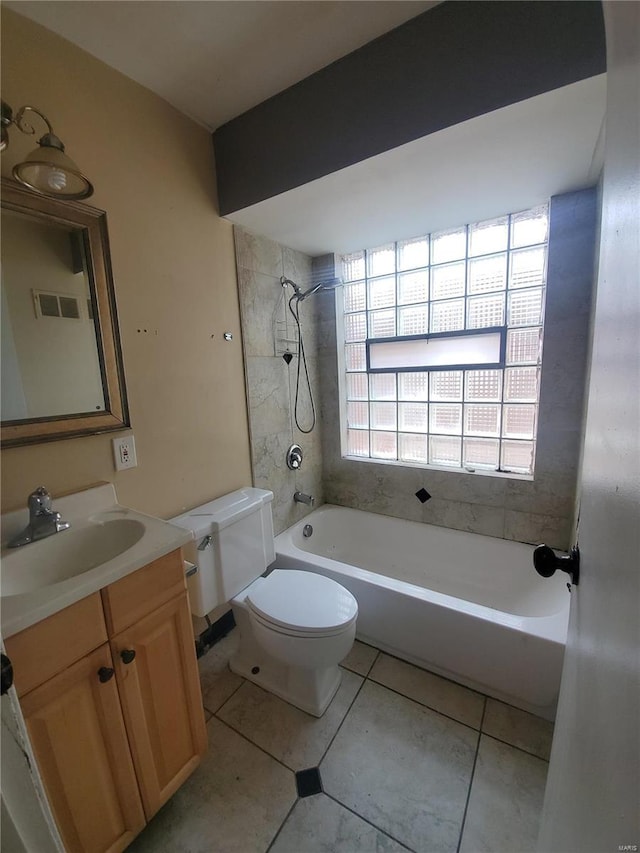 full bathroom with tile patterned flooring, tiled shower / bath combo, vanity, and toilet