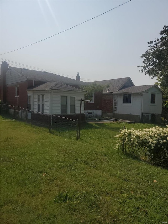 rear view of property with a lawn