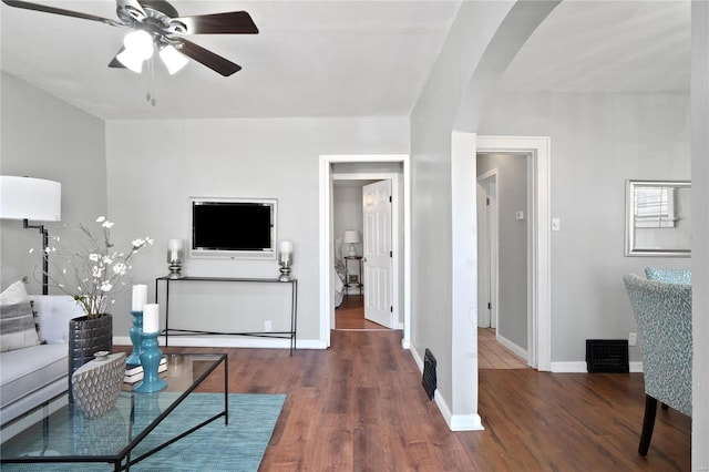 living room featuring dark hardwood / wood-style flooring and ceiling fan