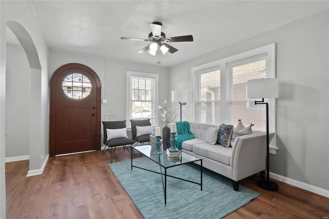 living room with wood-type flooring, ceiling fan, and a textured ceiling