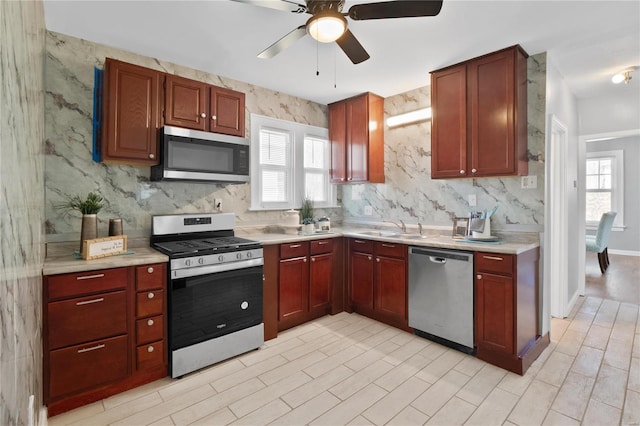 kitchen with ceiling fan, appliances with stainless steel finishes, plenty of natural light, and sink