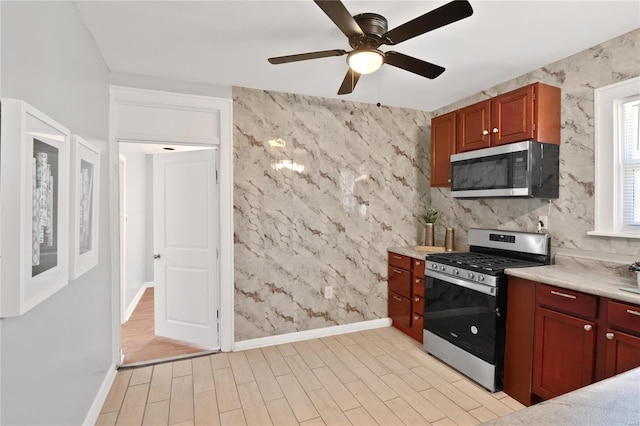 kitchen with light wood-type flooring, ceiling fan, and stainless steel appliances